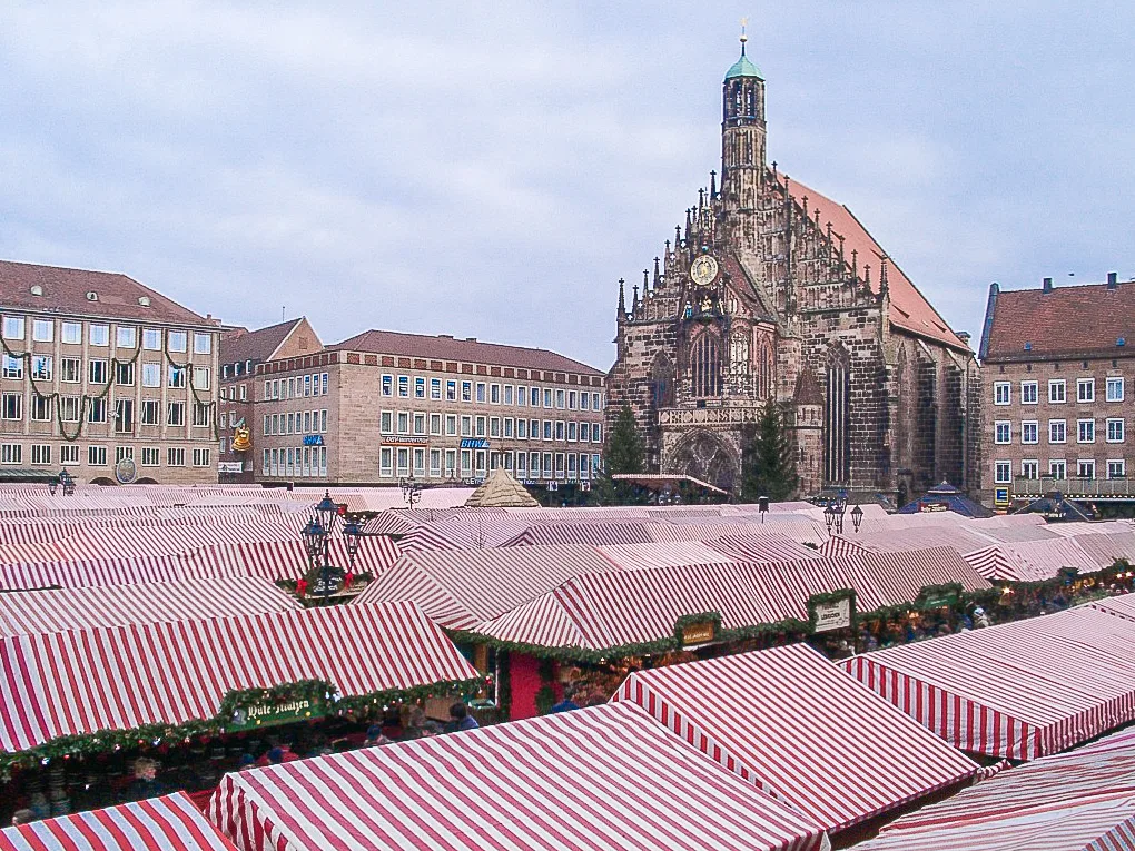 Red and white stalls of the Nuremberg Christkindlesmarkt on the Hauptmarkt at night — 2